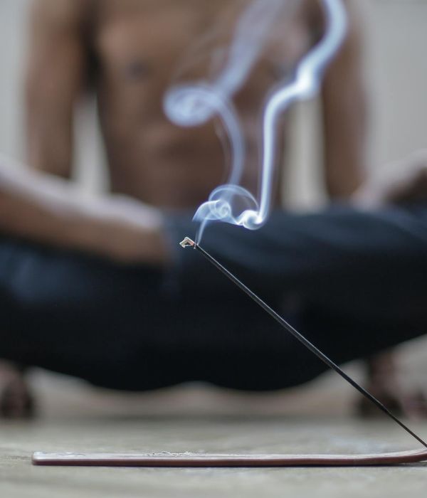Person practicing gentle yoga poses in a dark indigo room